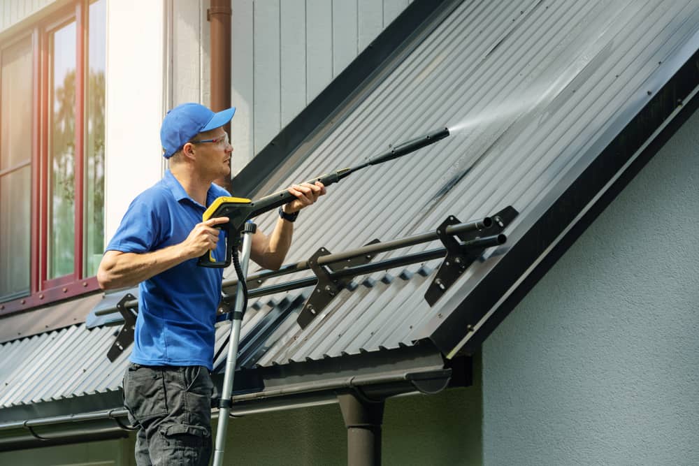 worker pressure washing roof in Bergen county